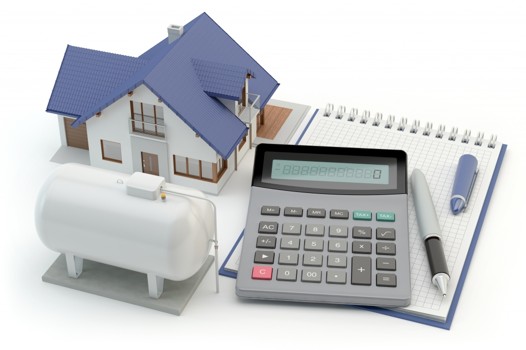 Maquette de maison, citerne de propane et calculatrice pour estimer son budget gaz